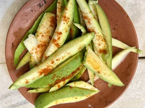 Experience the flavors of raw mango chat served in a traditional clay plate. Stock Photos