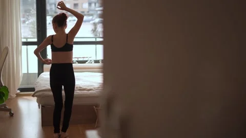 Experience the invigorating Morning Stretch in a Bright Bedroom, where you will Stock Footage 317021366
