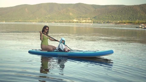 Experience the joy of a refreshing summer paddleboarding adventure on serene Stock Footage 280721499