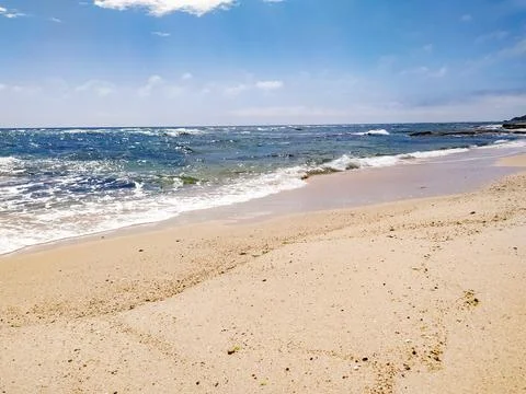 Experience pure tranquility on this empty sandy beach where gentle ocean wave Stock Photos