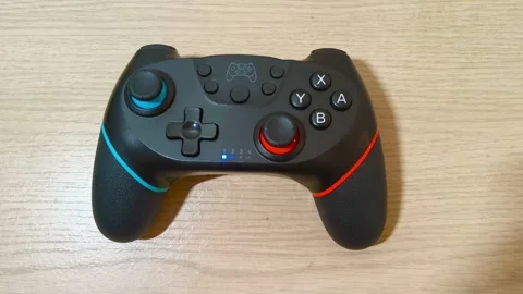 Experience seamless gaming with this modern black wireless gamepad, perfect for Stockbeeldmateriaal 318310892