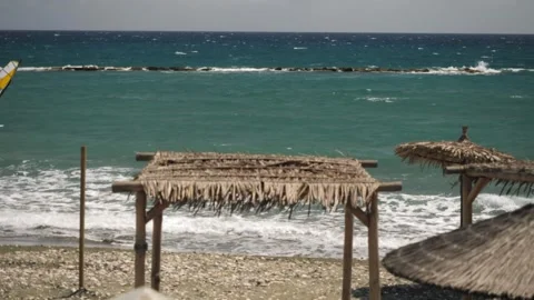 Experience Seaside Serenity Relaxing Beach Huts and Tranquil Waves Await This Stock Footage 302084580