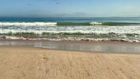 Experience the Serene Beach Waves that Dance upon the Golden Sand beneath C.. Stock Photos