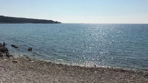 Experience a Serene Coastal View featuring a picturesque Pebbled Shoreline that Stock Footage 307351093