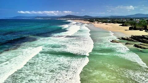 Experience the serene coastal view featuring gentle waves crashing against a Stock-Fotos