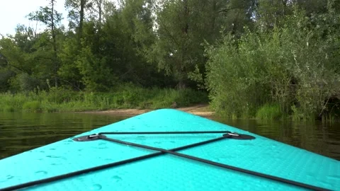 Experience the serene joy of paddleboarding, fully immersed in the peaceful Stock Footage 281606298