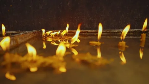 Experience serenity with floating candles reflecting in calm water at church Stock Footage 313731323