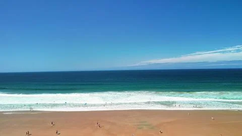 Experience the stunning beach waves gracefully crashing under a clear blue .. Foto stock