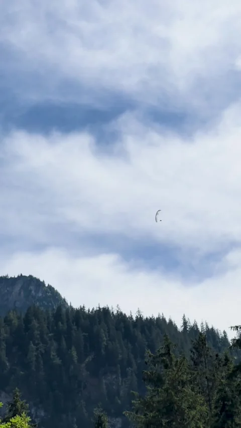 Experience the Stunning Paragliders Soaring Gracefully Over Majestic Mountains Stock Footage 307486559