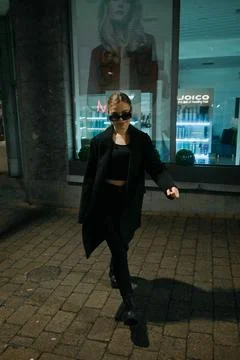 Experience a Stylish Night Walk While Embracing Urban Fashion in a Vibrant Foto stock