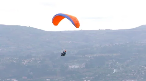 Experience the thrill of a solo paraglide flight over Patate City in Central Stock Footage 58603686