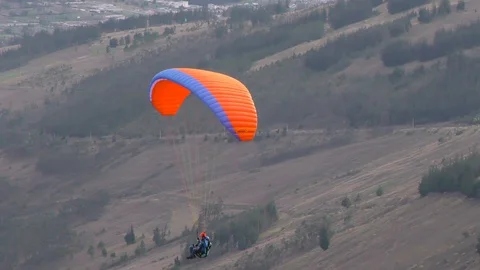 Experience the thrill of a solo paraglide flight over Patate City in Central 動画素材 128457812