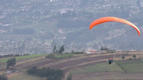 Experience the thrill of a solo paraglide flight over Patate City in Central Stock Footage 128457870
