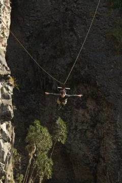 Experience the thrill of ziplining in Banos de Agua Santa,Ecuador,as a young man Stock Photos