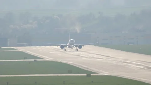 Experience the thrilling arrival of a passenger aircraft on a bustling runway Stock Footage 332576852