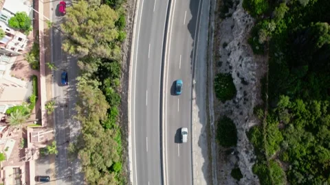 Experience a topdown view of a busy, twisting road surrounded by lush greenery Stock Footage 277950017