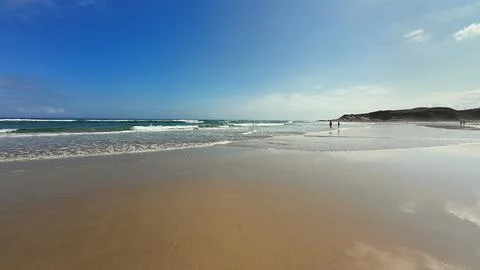 Experience a tranquil beach scene featuring gentle waves and a breathtaking.. Stock Photos