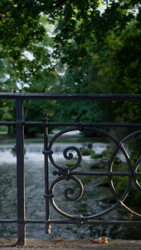 Experience the Tranquil Waterfall View Through Ornate Decorative Railings on a Video stock 318895829