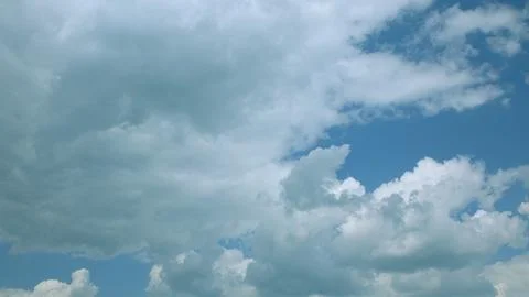 Experience vibrant cloud patterns in a bright blue sky on this clear, inviting d Stock Photos