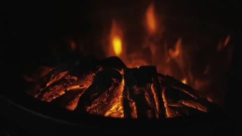 Experience the warm, glowing fire creating an inviting atmosphere in a dark Stock Footage 285829254