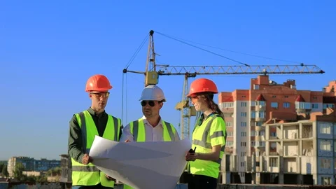 An experienced architect discusses a drawing on a construction site Stock Footage 128630859