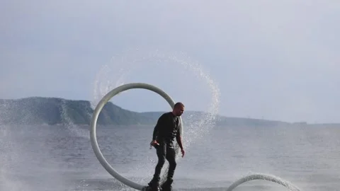 An experienced athlete does somersaults over water. Flyboarding is a new extreme Stock-Footage 243409678