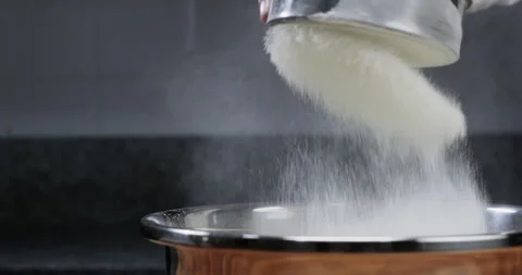 Experienced bakery chef sifting flour through sieve into the bowl Stock Footage 229954508