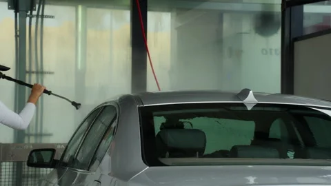 Experienced car cleaner using high-pressure water jet to meticulously wash .. Stock Footage 320890313