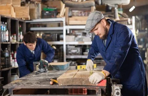 Experienced carpenter measures the length of board using tape measure. Preparing Foto stock