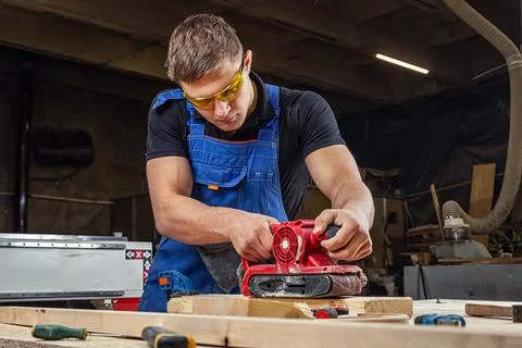 Experienced carpenter in work clothes and small buiness owner working in wood Foto stock