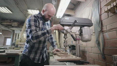 An experienced carpenter works with a drilling machine in his workshop. Stock Footage 194410039