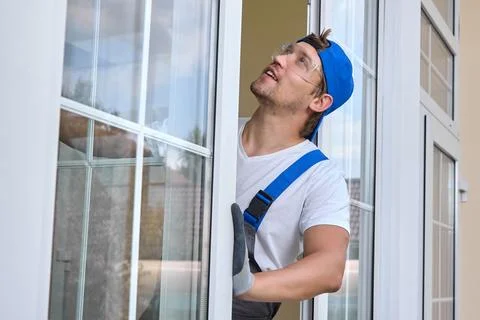 Experienced Caucasian master perform maintenance plastic windows office building Stock Photos