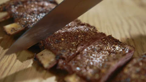 Experienced chef is cutting pork ribs in kitchen of restaurant. Stock Footage 88574392