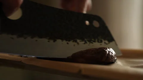 Experienced chef expertly using large cleaver knife to carve perfectly grilled Stock-Footage 290073040