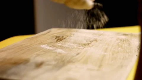 An experienced chef in a professional kitchen prepares the dough with flour to Stock Footage 156301336