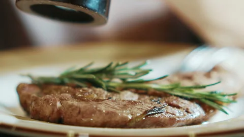 Experienced chef sprinkles fried meat with salt in kitchen of restaurant. Stock Footage 88572685