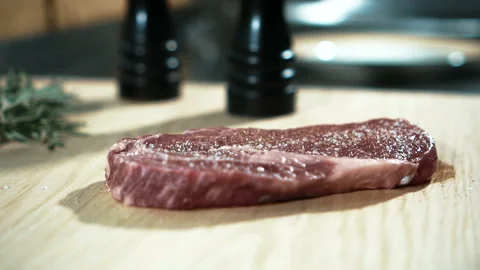 Experienced chef sprinkles piece of meat with greens in kitchen of restaurant. Stock Footage 86737460