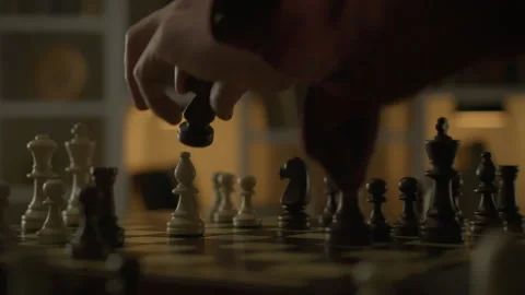 An experienced chess player confidently moves a piece, placing it in a squar Stock Footage 263590527