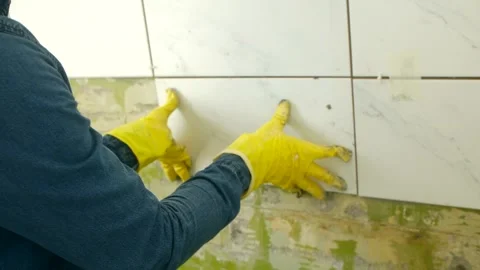 Experienced construction worker positions tile on wall Stock Footage 280302363