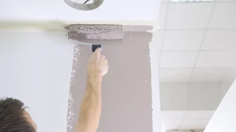 Experienced contractor colours white wall near ceiling Stock Footage 124892587