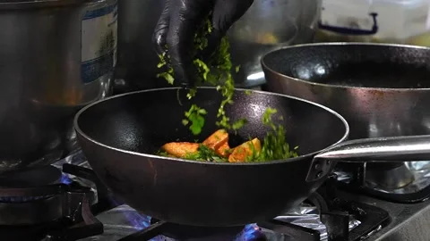 Experienced cook adding herbs and onions to fried potatoes. Stock Footage 267669939