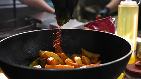 Experienced cook adding spices to pan-fried potatoes. Video stock 267299760