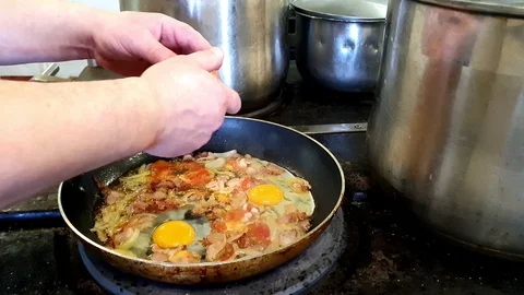 Experienced cook adds eggs to dish in vessel kitchen close Stock Footage 116768120