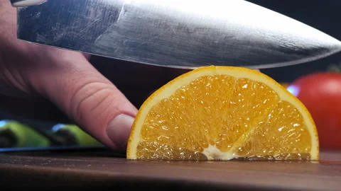 Experienced cook cuts fresh lemon into slices with knife Stockbeeldmateriaal 147014613