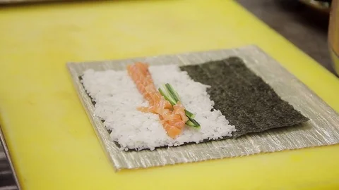 Experienced cook puts cucumbers on basis for rolls in kitchen of restaurant. Stock Footage 76380278
