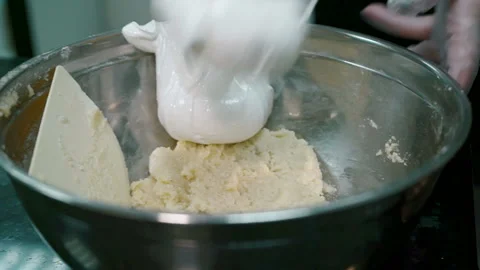 Experienced cook puts white mass in bowl in kitchen of restaurant indoors. Stock Footage 86748507