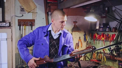 Experienced craftsman of weapons workshop inspecting semi-automatic hunting Stock Footage 167245650