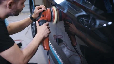 An experienced detailing studio worker polishing a car. Stock Footage 194990286