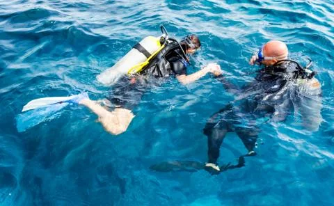Experienced diver instructor teaches a beginner diver to dive in Egypt Stockfoto's