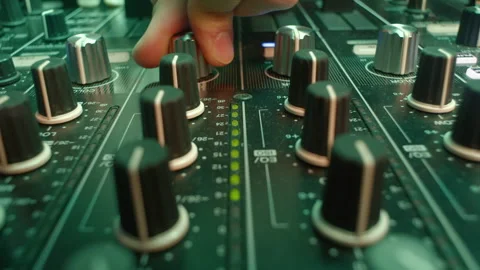 Experienced DJ twists knob to boost bass level on equalizer Video stock 273613431